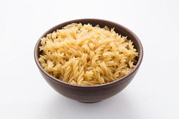 Spiral pasta in bowl on white background