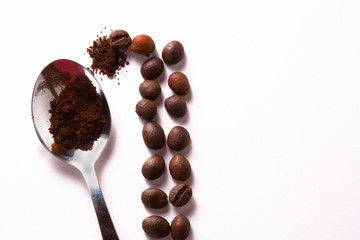 Grain of coffee, beans and a coffee spoon on a white background. Close-up