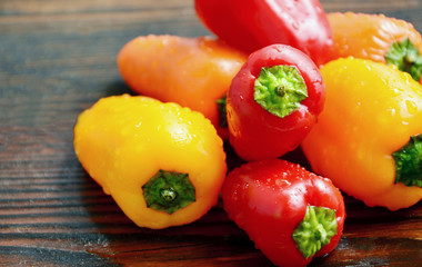 colorful of chili with water drop on wooden background.
Many color mixed paprika