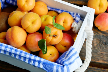 many fresh apricot with leaf in white wooden box