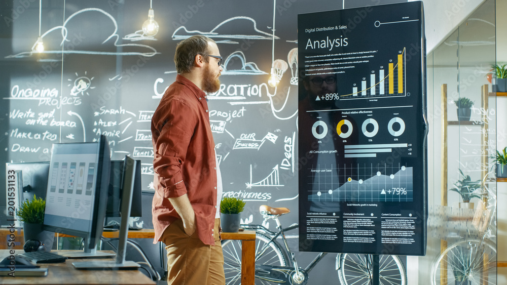 Aufkleber Marketer Looks at Interactive Touchscreen Whiteboard Showing Latest Graphs and Charts on Statistical Growth. He Works in the Creative Office.