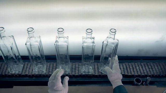 A worker looks for a defected bottles, top view.