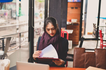 Fototapeta premium Business Concept.Young Asian businesswoman is working happily.Young businesswoman working in a cafe.Young businesswoman is relaxation in a coffee shop.