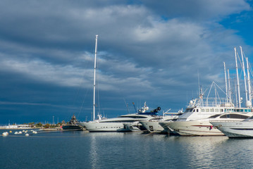 Fototapeta premium Nice view of the luxury boats in the port of Valencia with the blue sky and clouds at sunset