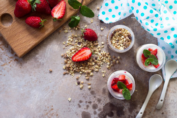 Homemade healthy breakfast with homemade baked granola, fresh strawberry and yogurt on stone or concrete table. Copy space, top view flat lay background.