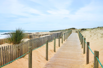 Fototapeta na wymiar Wooden path on the Atlantic beach with ocean view