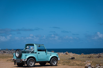 Obraz na płótnie Canvas Old exotic jeep parked near ocean