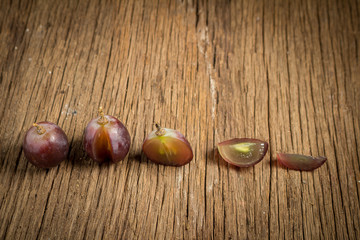 red grapes. slice. half. on wooden table