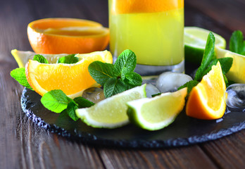 Fresh summer tropical citrus fruits with a mint on a stone stake. Igredients for a sweet summer lemonade.