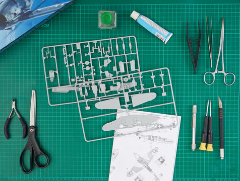 Plastic model kit and tools, hobby workplace background top view