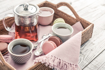 Different kinds of macaroons with glass teapot