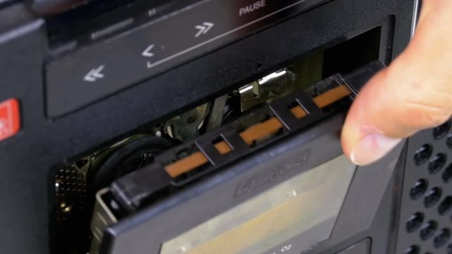 Insert Vintage Audio Cassettes into the Tape Player and Pushing Play, Stop Buttons