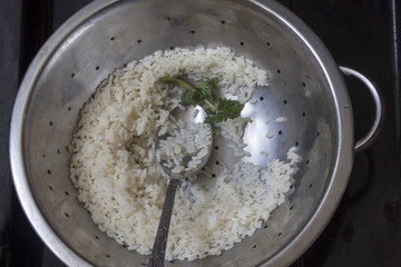 cooked rice in an old colander