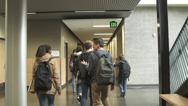 Medium shot of students walking in school corridor