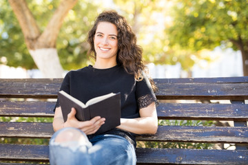 Pretty woman in park with a book