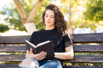 Beautiful woman reading book in park
