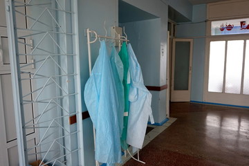 A medical robe hangs on a hanger at the entrance to the hospital