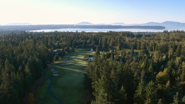 Golf resort grounds, mountains and forest in background. 