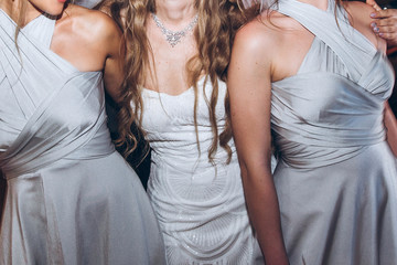 happy stylish bride and bridesmaids dancing and having fun at wedding reception in restaurant. guests dancing in light, people in motion at party in club. fun moments.