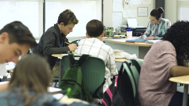 Wide shot of students writing in classroom