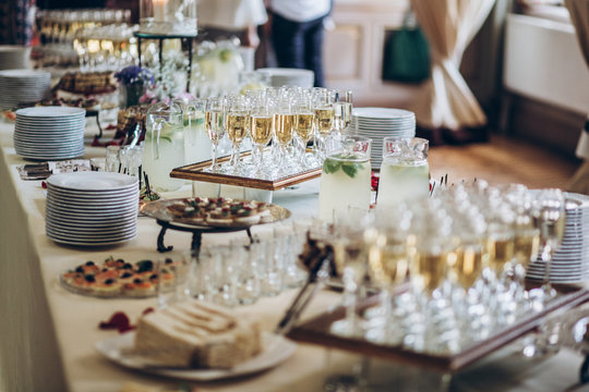stylish champagne glasses and food  appetizers on table at wedding reception. luxury catering at celebrations. serving food and drinks at events concept