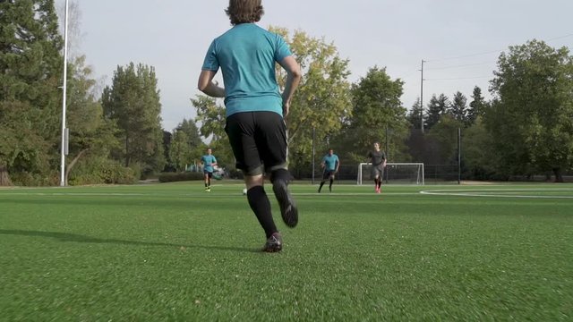 Male soccer players playing soccer.