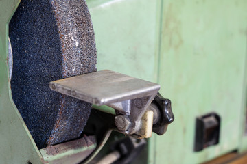 Bench grinder for locksmith's work on a wooden table. Locksmith accessories for small repairs.
