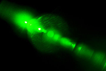 Camera lens flare by laser light create hexagons of objective iris shapes of number depending on number of lens surface and interferent effect and moire on digital sensor on dark black background