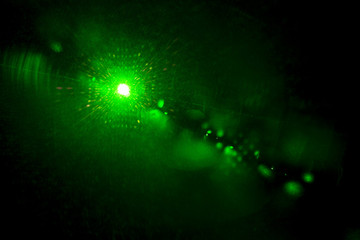 Camera lens flare by laser light create hexagons of objective iris shapes of number depending on number of lens surface and interferent effect and moire on digital sensor on dark black background
