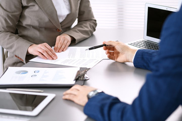 Business people and lawyer discussing contract papers sitting at the table, closeup view