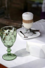 A cup of latte macchiato on the table with white tablecloth