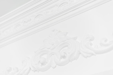 Stucco elements on white wall. Luxury design with mouldings. Beautiful ornate white decorative plaster in studio