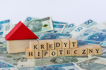 Words mortgage written in polish with wooden blocks standing on money - obrazy, fototapety, plakaty