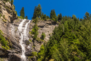 Blick auf einen hohen Wasserfall in den Bergen unter blauem Himmel