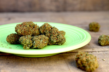 Cannabis Buds on Green Plate and Wood Background