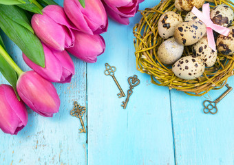 Spring background. Bouquet of flowers on a wooden background and a nest with eggs. spring