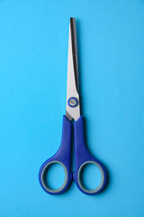Scissors with plastic handles on a blue background.