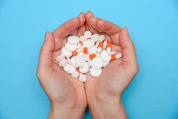 The girl holds in her hands of various tablets, pills, medicines pharmacological group.