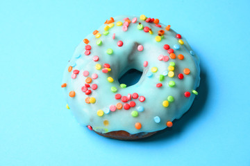 Sweet donut on blue background with copy space.