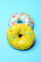 Two sweet festive donuts on blue background close up food.