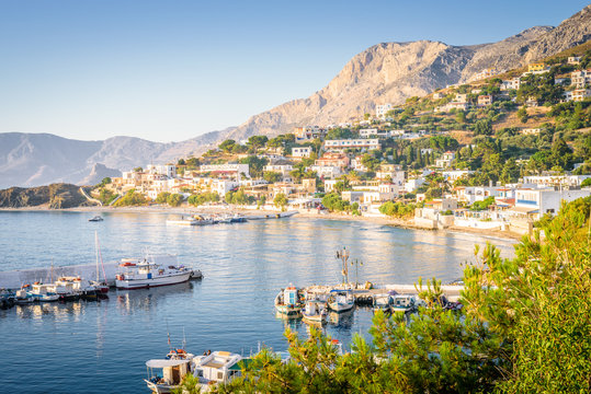Kalymnos Island, Massouri, Kos, Dodecanese, Greece: Beautiful sunny village town harbor view to the greek blue sea with crystal clear water with fishing boats cruising holiday yacht laying on shore