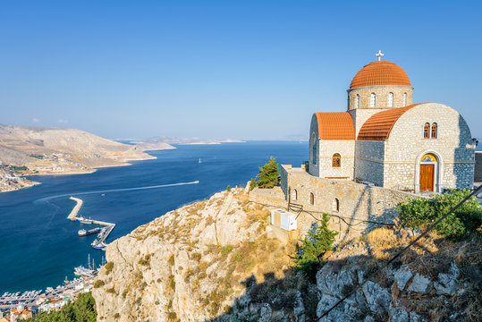 Beautiful mediterranean greek colorful holy monastery Agios Savvas situated on a mountain high above the town of Pothia, Kalymnos Island, Kos, Dodecanese, Greece