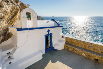 Beautiful blue white greek church called Agios Georgios situated at the cliffs reachable by steps...