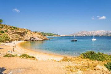 Beautiful sunny coast view to the greek blue sea with crystal clear water beach with some boats fishing cruising surrounded by hills, Kokkina Beach, Leros, Dodecanese Islands/ Greece – July 18 2017