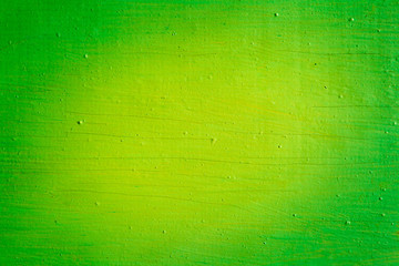 Texture of a wooden board painted in green and yellow with cracks and irregularities for the background.