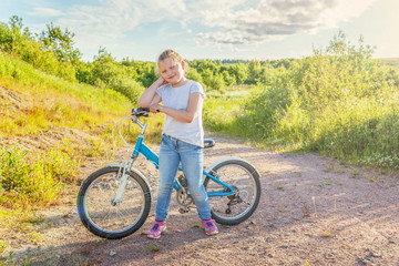 Obraz premium Happy child riding bike. Young girl on bicycle in sunny summer park. Healthy school children summer activity. Kids playing and cycling outdoors. Little girl learns to keep balance while riding bicycle
