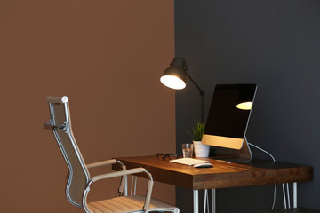 Comfortable workplace with modern lamp and computer