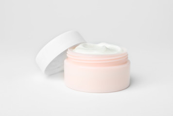 Jar of cosmetic product on light background