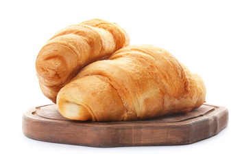Wooden board with tasty croissants on white background