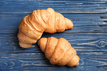 Tasty croissants on wooden background, top view